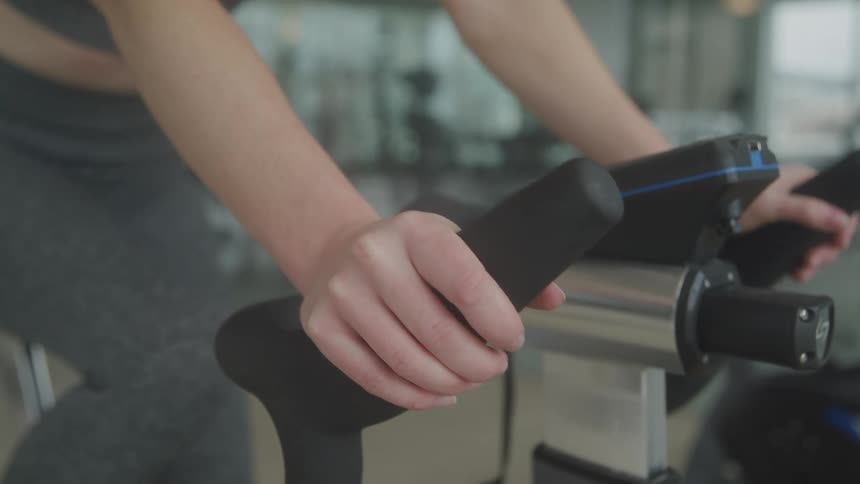 Female getting ready to work out on stationary bike at the gym