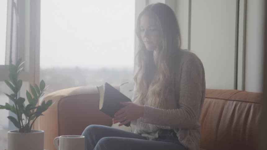 A woman picks up her book to read