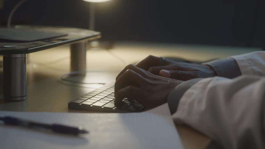 A person is typing fast on the keyboard in the office