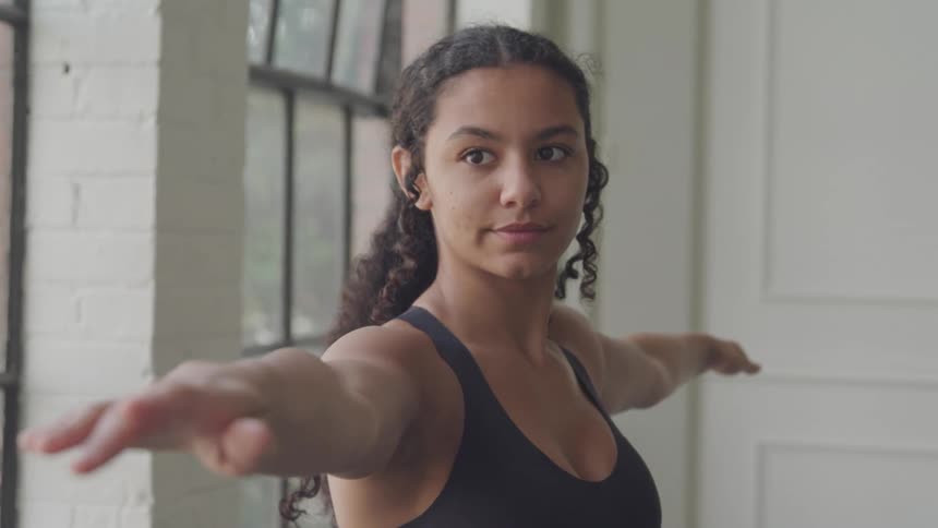 A woman is doing yoga by the window
