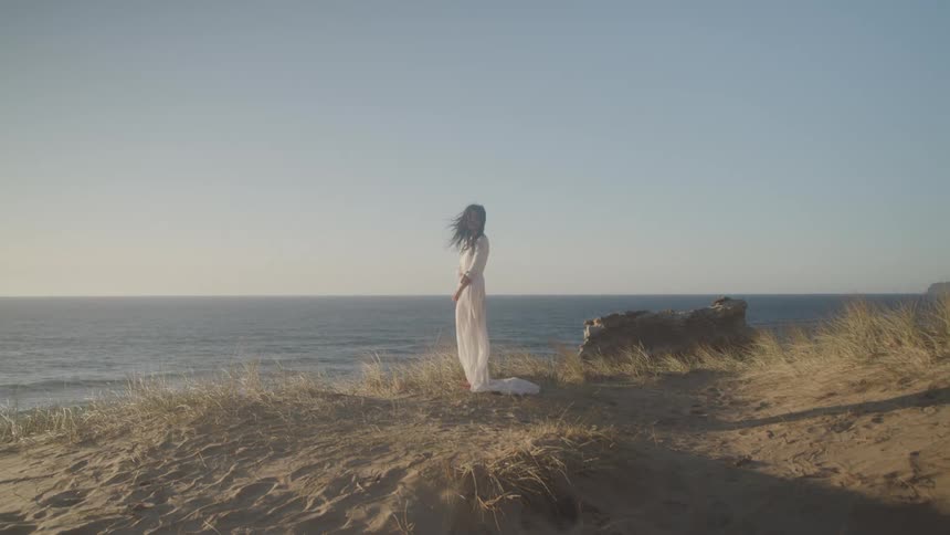 A footage of a lady standing by the sea shore