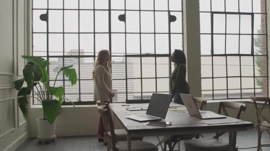Two women greet each other in the office