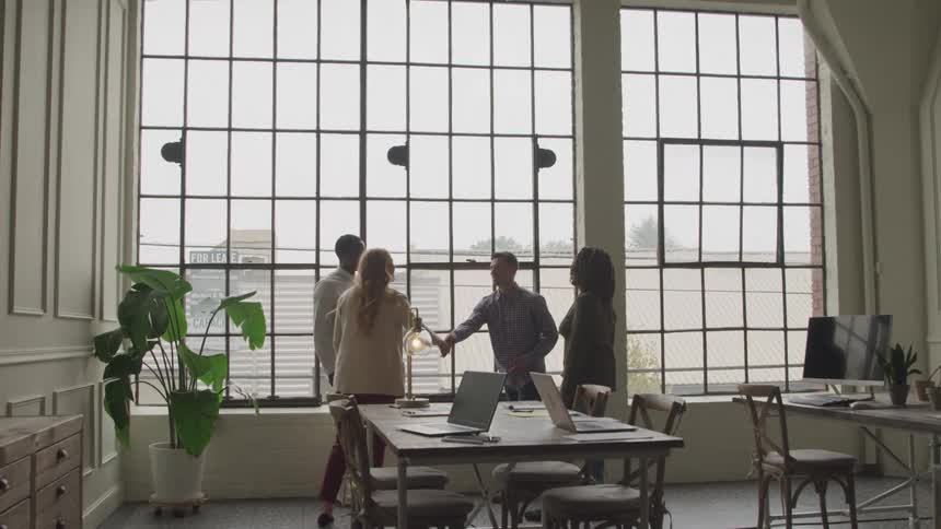 People greet each other in the office by the window