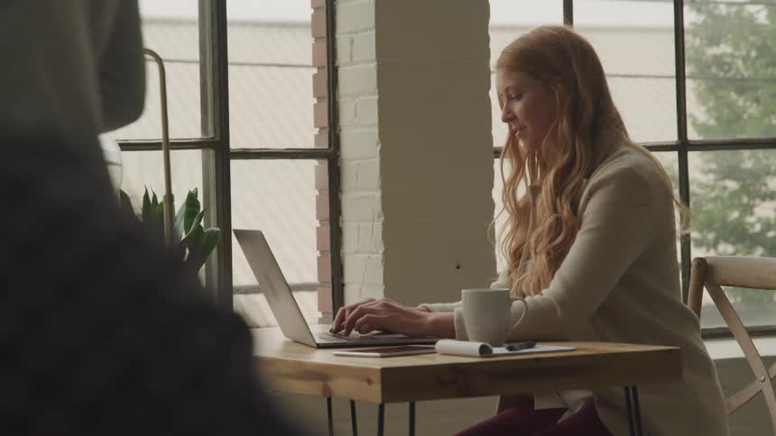 Girl sitting at a table typing on a computer