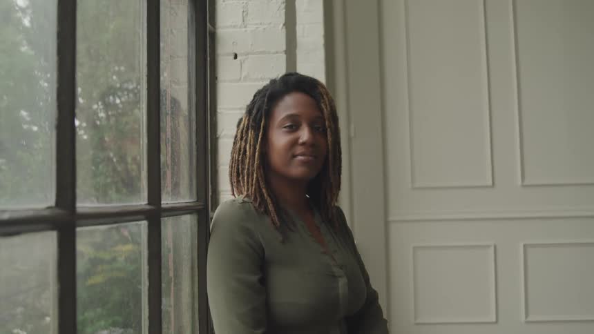 A footage of a lady smiling close to the window