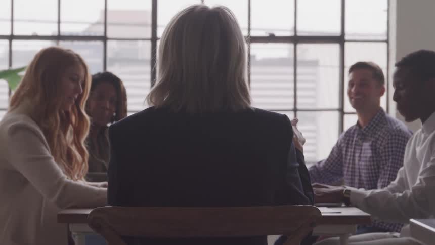 People are listening to a woman at the meeting