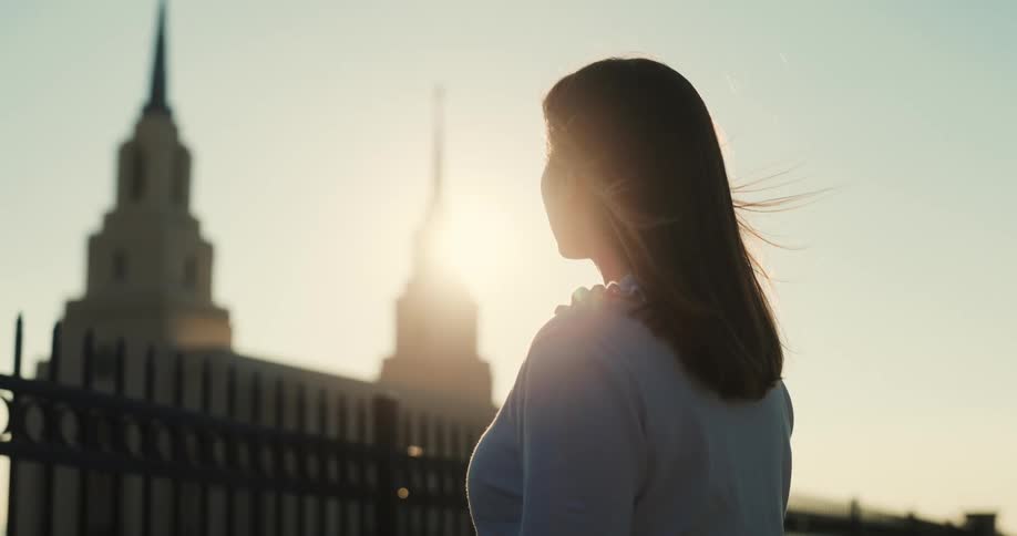 A side view of a lady standing outdoor