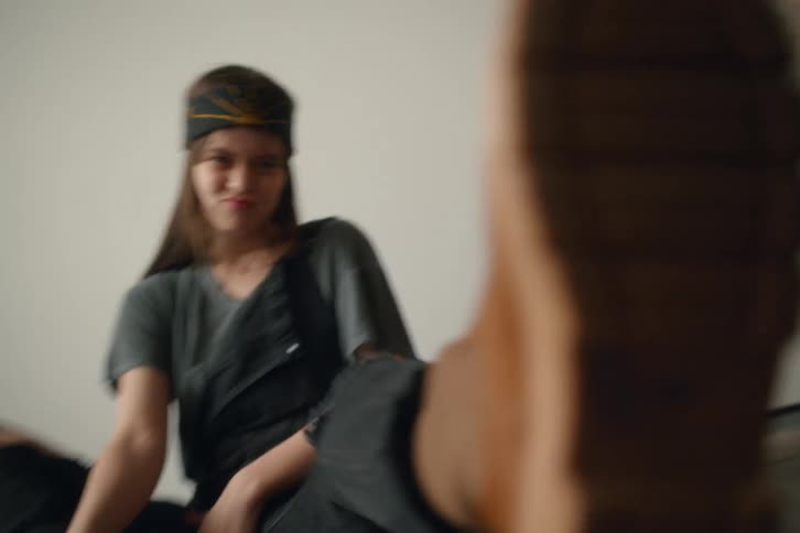 A woman kicks the camera with her boot