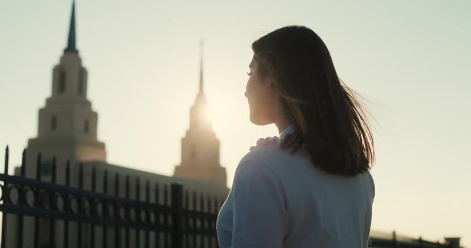 A woman stands outside on windy day