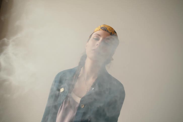 Footage of a lady in a smokey room