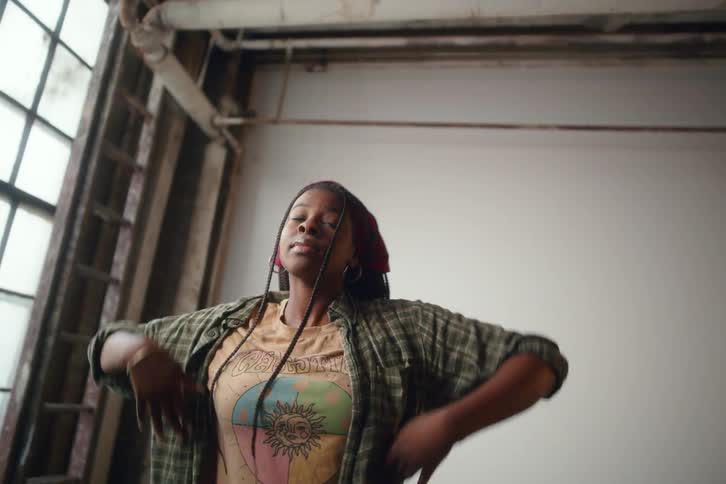 A woman is dancing freely in a well lit room