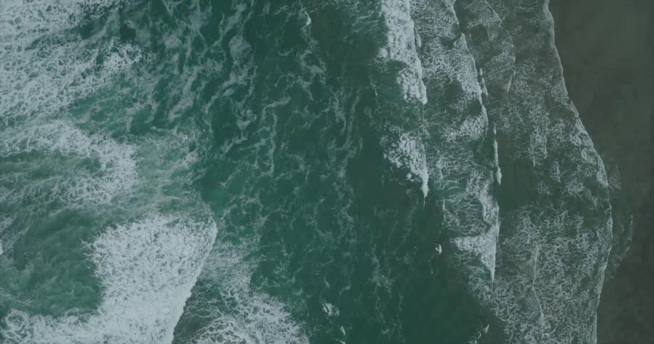 Aerial of waves rolling onto a sandy shoreline