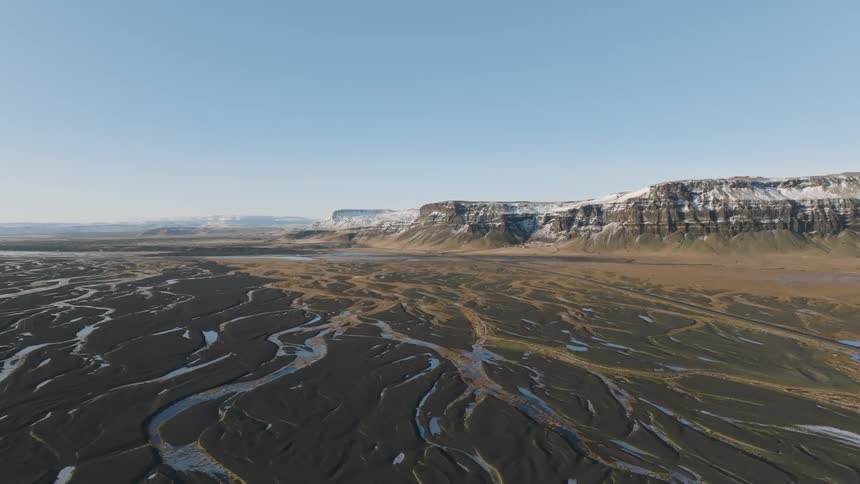 An aerial footage of a swamp close to a mountain