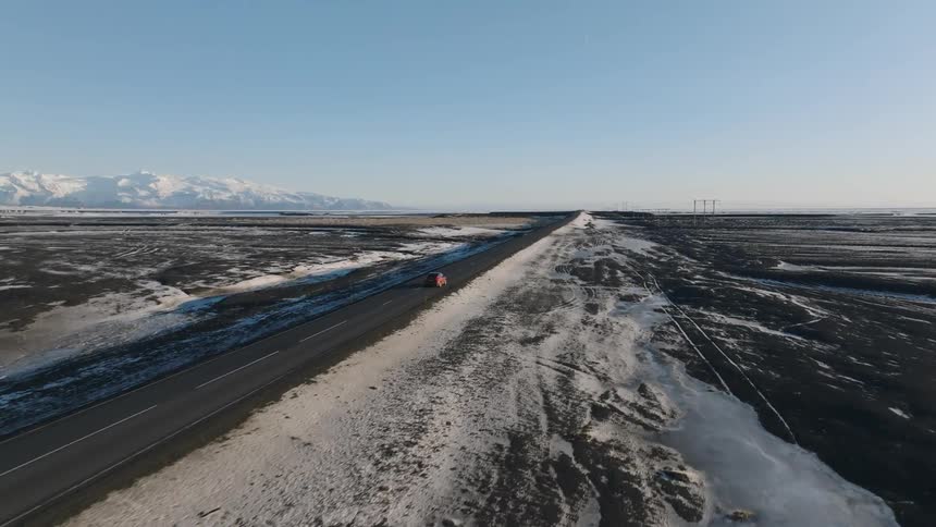 A car drives past the frozen landscape