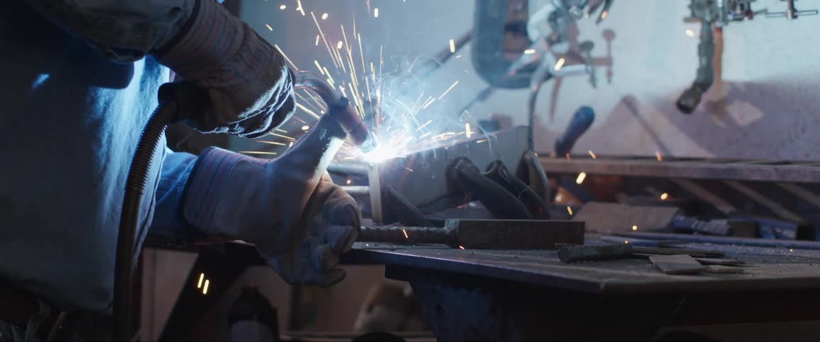 A man is welding on the bench