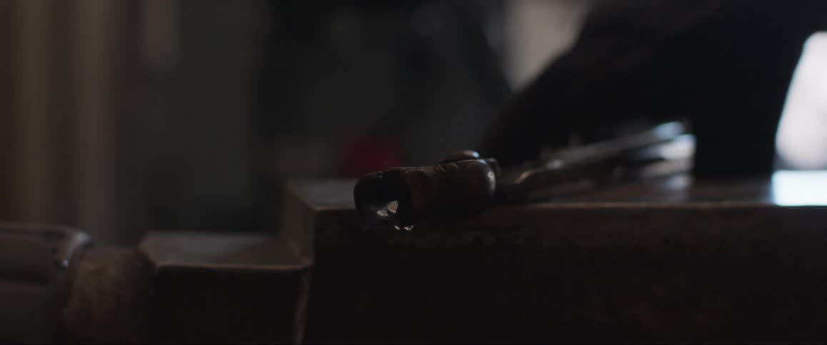 A blacksmith picks up the cooling metal off the anvil