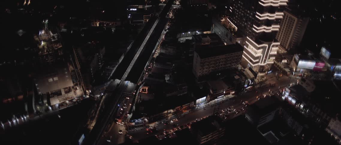 Traffic moves along a highway in a city at night