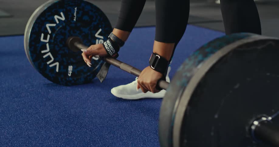 A woman is dead lifting in the gym