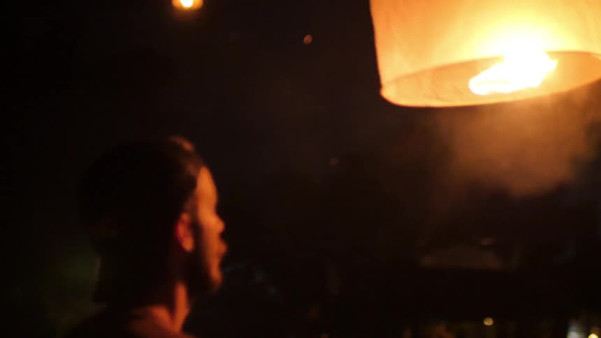 People lighting paper lanterns