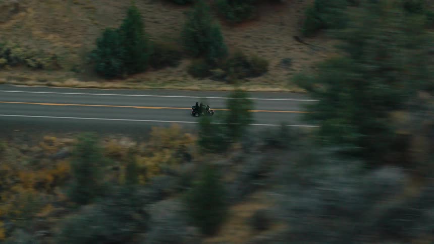 A motorcycle passes the hills on the highway