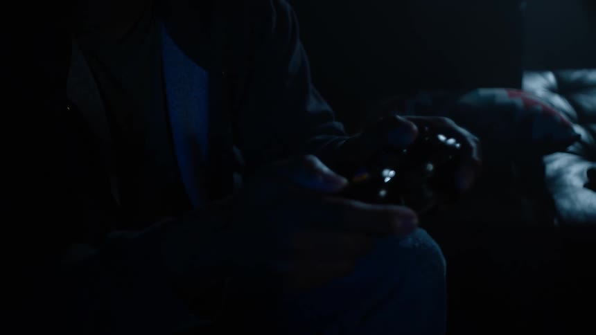 A man is playing video games in the dark