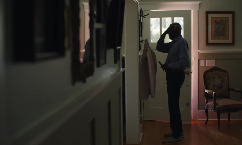 A man is combing his hair by the door