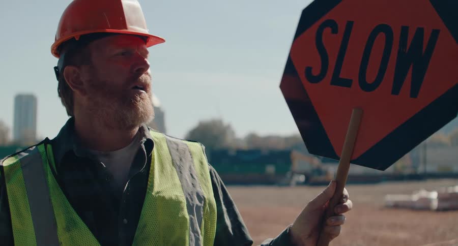 A footage of a man holding a signpost