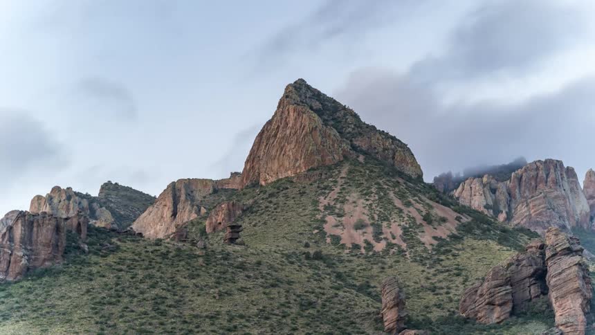 The clouds flow over the mountain peak
