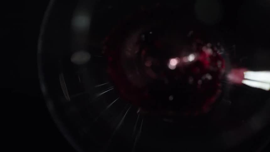 A footage of red wine in a glass cup