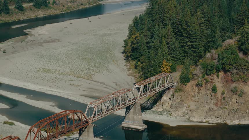 A rusty railroad bridge crossing a river