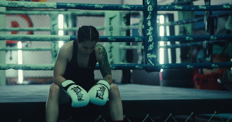 A boxer is resting in the gym