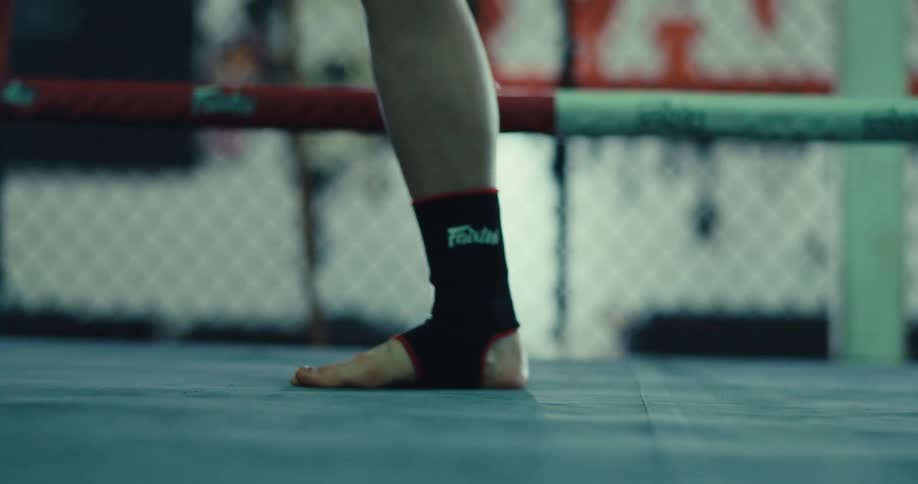 A woman is moving fast around the boxing ring