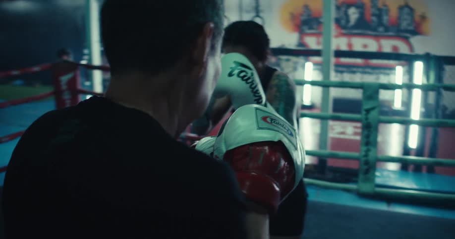 A man and woman are sparring in a boxing ring