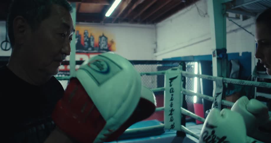 A woman gives a spinning elbow to her sparring partner