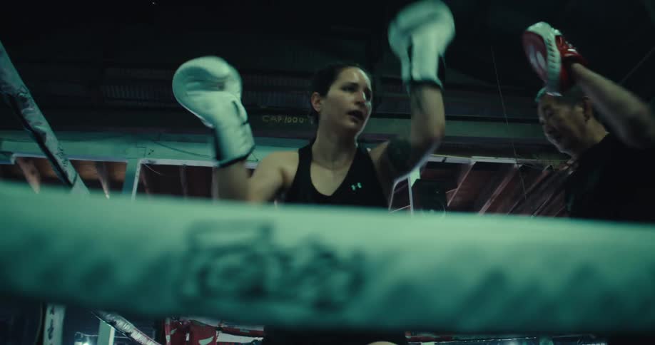 A woman boxing with a trainer