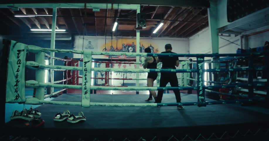 A woman sparring with a boxing instructor
