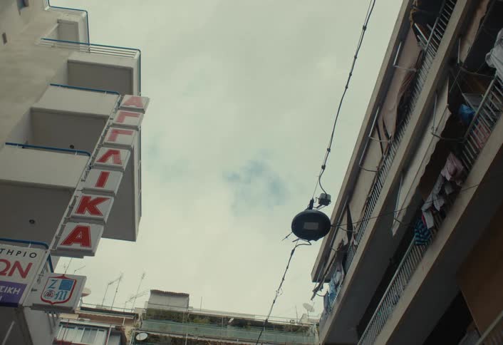 A bird flies up on top of a sign on the building