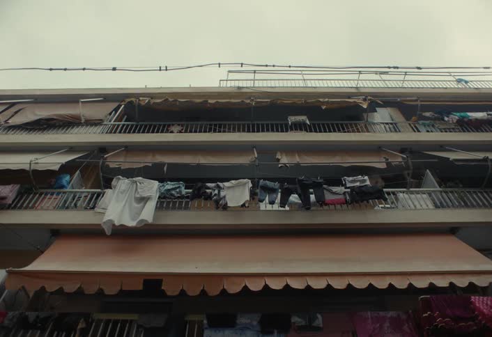 Clothes hang from the balcony on the apartment