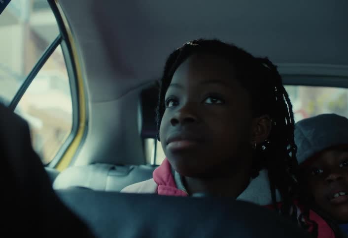 A girl looks around in the backseat of the car