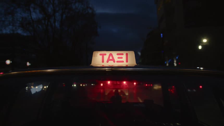 The taxi travels through the city at night