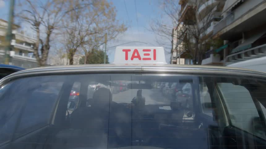 The taxi drives down the narrow road in the city