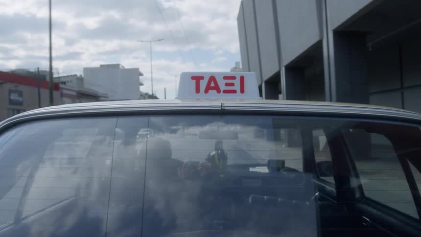 A view from the exterior of a moving taxi driving through the city and passing beneath a bridge