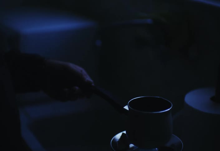 Man in the darkness cooking something in a pot