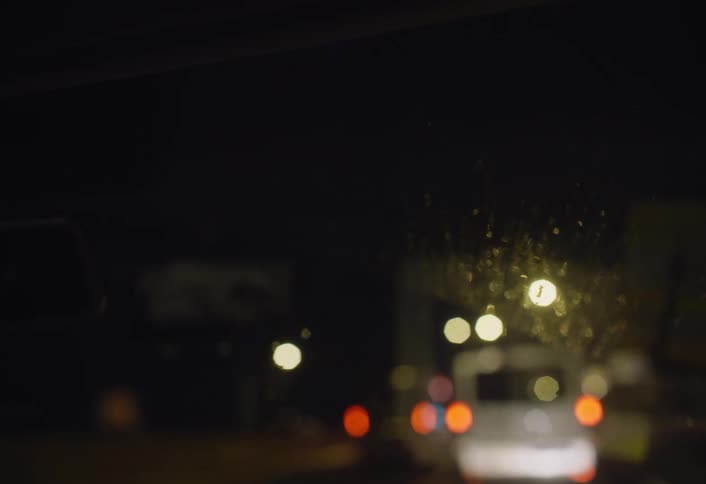 Cars drive in traffic at night