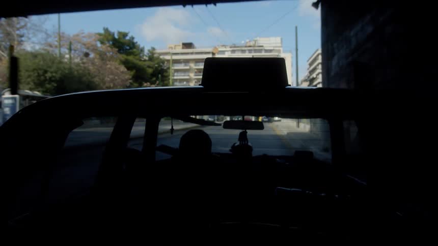 A view from the exterior of a moving taxi driving through the city and passing beneath a bridge