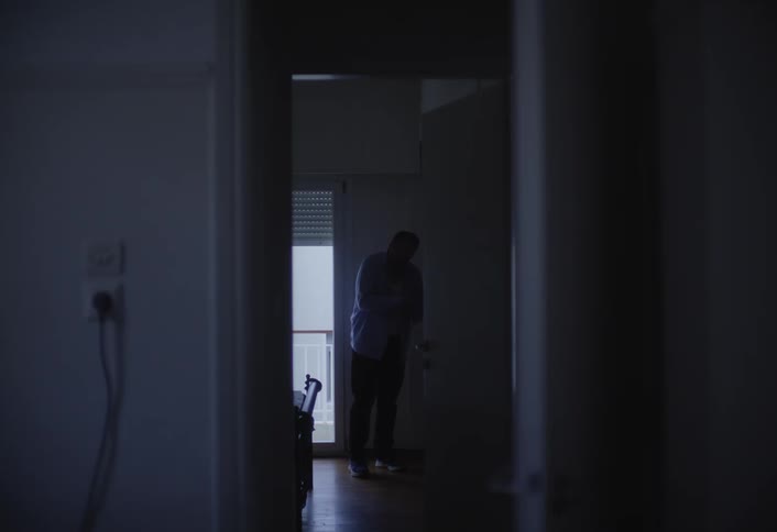 A man is getting dressed down the hall