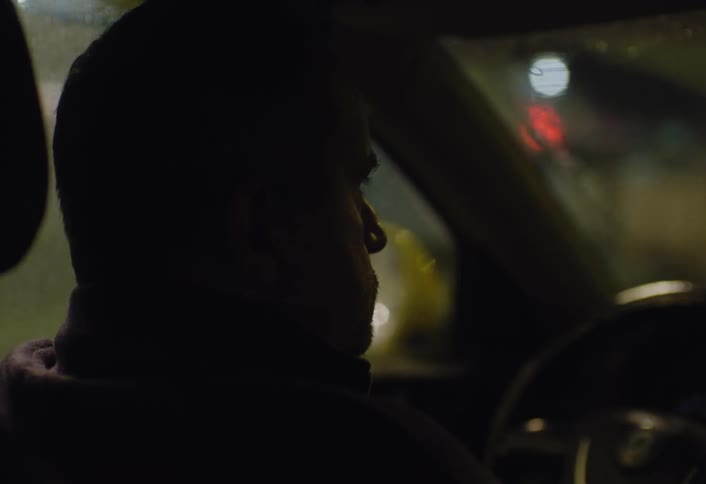 A man is driving at night in the city