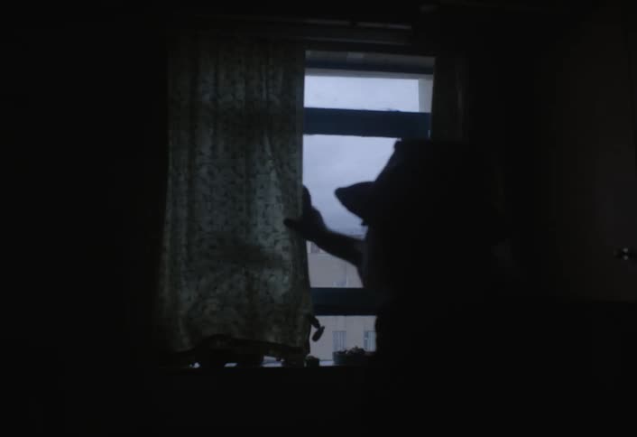 A footage of a man opening a curtain