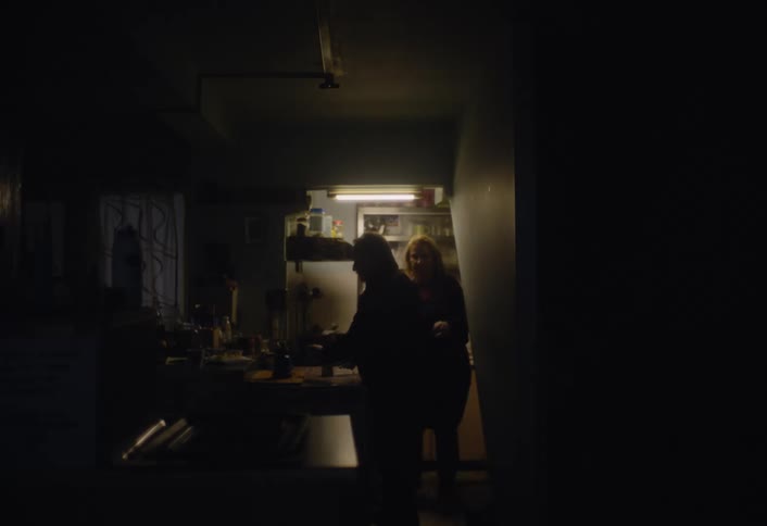 Elderly couple moves around in the kitchen