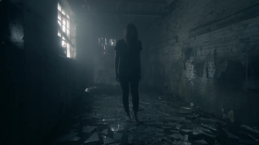 Woman standing in a dark secluded area indoors